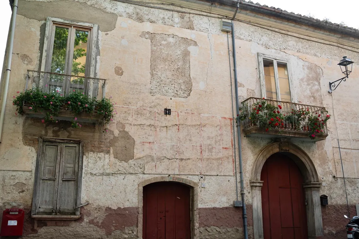 La facciata in pietra dell'osteria nel borgo di Aterrana